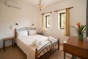 - une chambre avec un lit, une table et des fenêtres dans l'établissement Villa Luisa Exclusive Residences, à Monemvasia