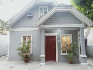 サンタローザにある# 15 Laguna Bel-Air Home in Sta Rosa by Red Door House Rentalの赤い扉と鉢植えの植物が2つある家