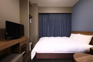 Habitación de hotel con cama y TV de pantalla plana. en Dormy Inn Express Fujisan Gotemba, en Gotemba