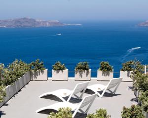 un patio con sedie e l'oceano sullo sfondo di Hotel Thireas a Firà