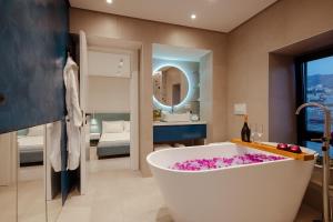 ein Badezimmer mit einer großen Badewanne mit rosa Blumen in der Unterkunft Artis Blue Relax in Himarë