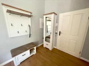 een kamer met een kast met een spiegel en een deur bij Gästehaus Sternschanze - App 4 Obermaat in Stralsund