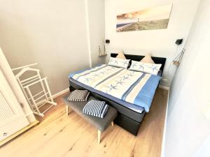 een kleine slaapkamer met een bed en een stoel bij Gästehaus Sternschanze - App 4 Obermaat in Stralsund