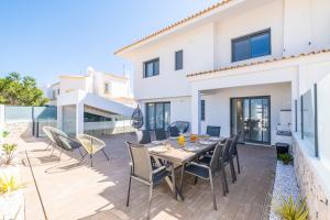 einen Essbereich mit einem Tisch und Stühlen auf einer Terrasse in der Unterkunft Atlantis Luxury Villa in Galé