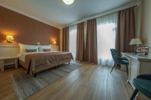 um quarto de hotel com uma cama e uma secretária em Wellness Hotel Pivovar Monopol em Teplice