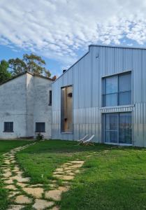 un edificio blanco con una puerta y un patio de césped en Anonima Agricola, en Orbetello