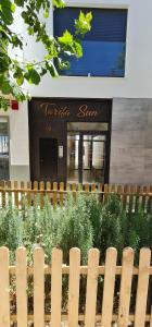 Apartamentos Tarifa Sun في تريفة: حاجز خشبي أمام مبنى veritas sun