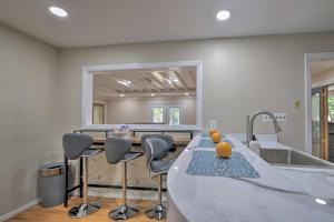 a kitchen with a counter with chairs and a sink at Coastal Edgewater Home with Private Hot Tub! in Annapolis