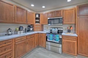 a kitchen with wooden cabinets and a stove top oven at Coastal Edgewater Home with Private Hot Tub! in Annapolis