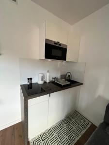 uma pequena cozinha com um lavatório e um micro-ondas em Apartament Love Góry Karpacz Centrum em Karpacz