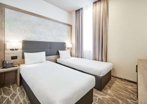 Radisson Hotel City Centre Odesa في أوديسا: غرفة فندقية بسريرين ونافذة