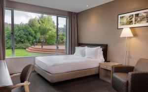 Rydges Rotorua في روتوروا: غرفه فندقيه بسرير ونافذه