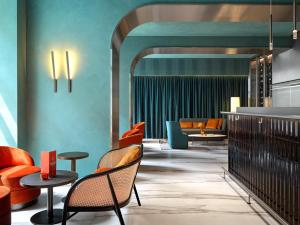 een lobby met stoelen en tafels en een bank bij The Julius Prague in Praag