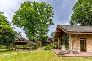 een stenen huis met een terras en een tuinhuisje bij Harmony Park Countryside Villas & SPA in Prienai