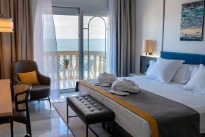 a hotel room with a bed and a balcony at URH Sitges Playa in Sitges