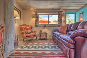 sala de estar con sofá de cuero y silla en Authentic Adobe Abode Less Than 1 Mile to Sante Fe Plaza!, en Santa Fe