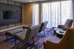 una sala d'attesa con sedie e TV a schermo piatto di Sonesta Select Indianapolis Carmel a Carmel