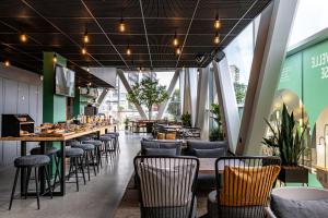 a restaurant with a long bar with chairs and tables at Best Western M-Treize Paris Asnieres in Asnières-sur-Seine