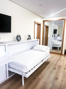 Dieses weiße Zimmer verfügt über ein Bett und einen TV. in der Unterkunft Encosta do Monte in Ponte de Lima