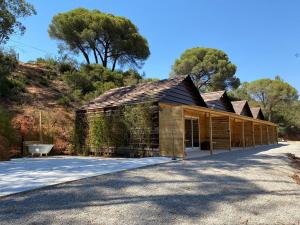 a wooden barn with a building at FALCOARIA de Santa Efigenia in Setúbal