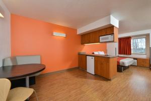 an orange room with a kitchen and a table at Motel 6-Meridian, ID - Boise W in Meridian