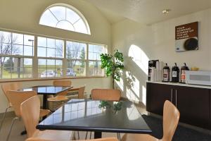 a dining room with two tables and chairs and windows at Motel 6-Meridian, ID - Boise W in Meridian