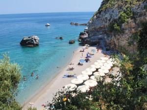 uma praia com guarda-sóis e pessoas na água em Olga Studios em Tsagarada