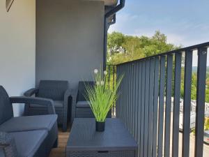 een balkon met een tafel met een plant erop bij Apartamenty Ski & Fun Spokojna in Wisła