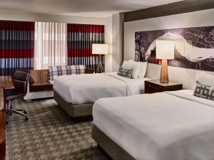 フィラデルフィアにあるSonesta Philadelphia Rittenhouse Squareのベッド2台とデスクが備わるホテルルームです。