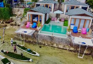 uma vista aérea de uma casa com piscina e dois barcos em Indigo Blue Ceningan em Nusa Lembongan