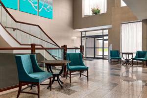 una hall con sedie, tavolo e scale di Ramada Plaza by Wyndham Niagara Falls a Niagara Falls