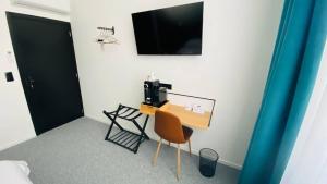 een kamer met een bureau, een stoel en een televisie bij BED Cauchy in Namen