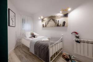 a bedroom with a bed with a painting on the wall at Eromeni Apartments in Biały Dunajec