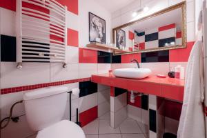 a red and white bathroom with a toilet and a sink at Eromeni Apartments in Biały Dunajec