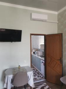 a room with a table and a television and a kitchen at Апартаменти в Старому Місті Sweet House in Kamianets-Podilskyi