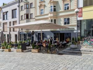 patio z parasolem i ludzie siedzący przy stołach w obiekcie Platzhirsch Kufstein w mieście Kufstein