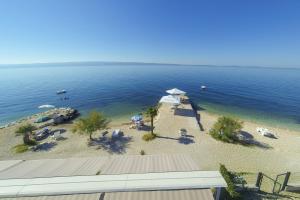 una spiaggia con sedie e ombrelloni in acqua di Pansion Amigos a Podstrana