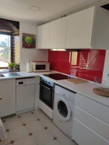 a kitchen with white cabinets and a washing machine at Bonito apartamento en Laredo in Laredo