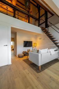 uma sala de estar com um sofá branco e uma escada em Madrid Suites em Maastricht