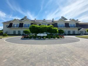 ラドムにあるHotel Lordの目の前に木々が植えられた白い大きな建物