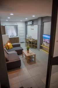 a living room with two couches and a tv at BILLYS HOUSE in Tríkala