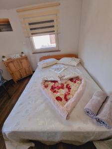 a bed with a heart shaped pizza on it at Hostel BellaVista in Koper