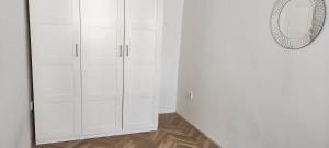 un armadio bianco con specchio e pavimento in legno di Apartment Green House - Old Town a Bratislava