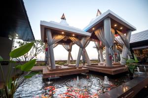 una casa con un laghetto koi nel cortile di Nouvo City Hotel a Bangkok