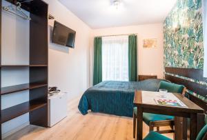 een hotelkamer met een bed en een tafel en een kamer bij Willa 4 Pory Roku in Kazimierz Dolny