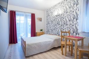 een slaapkamer met een bed, een tafel en een raam bij Willa 4 Pory Roku in Kazimierz Dolny