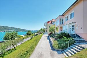 dom ze schodami obok wody w obiekcie Appartements Schwarzvilla w mieście Velden am Wörthersee