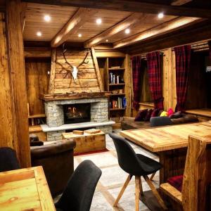 sala de estar con chimenea, mesa y sillas en FORESCH HUS CHAMBRES D'HOTES, en Gressoney-Saint-Jean