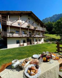 una mesa con comida delante de un edificio en FORESCH HUS CHAMBRES D'HOTES, en Gressoney-Saint-Jean