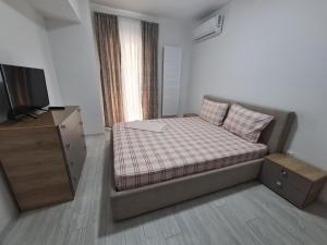 Dormitorio pequeño con cama y TV en Apartament Moghioros Park Residence DUM1, en Bucarest